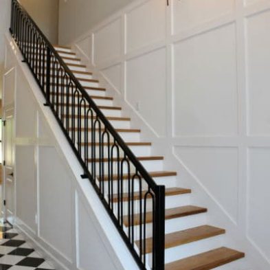 Transitional home with wainscot detail around the stairs